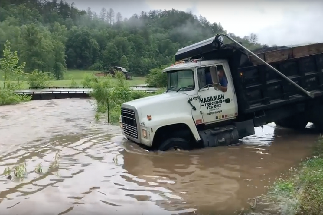 VIDEO: This dump truck driver ain't about to let a raging creek stop him