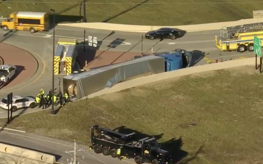 Truck hauling paper rolls TOPPLES due to load shift on roundabout in Missouri